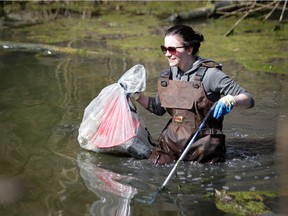 Sharron Picotte wades through a pond along the Ganatchio trail looking for trash during the second annual Ganatchio Trail cleanup honouring attack victim Anne Widholm Saturday, April 13, 2019.