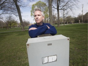 Steven Palmer, a professor of history at the University of Windsor, leans on a large electrical box in the middle of a grassy patch at Willistead Park, Friday, April 26, 2019.