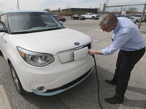 Dan Campeau, a sales agent with Gus Revenberg Kia in Windsor is shown with a 2019 KIA EV Soul Luxury electric car on Wednesday, April 24, 2019.