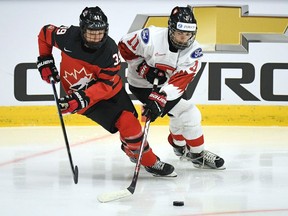 Ann-Sophie Bettez of Canada, left, and Sinja Leemann of Switzerland vie for the puck, during the Hockey Women's World Championships preliminary match between Switzerland and Canada in Espoo, Finland, April 4, 2019.