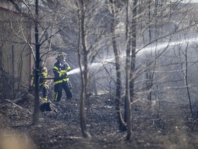 Fire crews battle a fire that originated on the Zalev Brothers property but quickly spread to an adjacent empty grass lot, threatening surrounding businesses, Wednesday, April 3, 2019.  No injuries were reported in the fire.