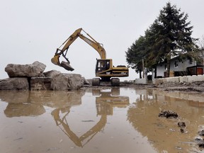 A heavy equipment operator moves massive rocks to enforce a breakwall around a shoreline property on Cotterie Park Rd in Leamington, ON. on Tuesday, April 30, 2019. Recent rain and high winds prompted the Essex Region Conservation Authority to issue a flood warning in local areas.