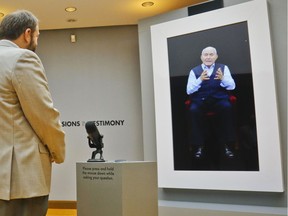 In this Friday Sept. 15, 2017, photo, New York Councilman Rory Lancman, left, listens to a virtual response to his question from Holocaust survivor Pinchas Gutter, right, featured in a testimonial interactive installation called "New Dimensions in Testimony" at the Museum of Jewish Heritage, in New York. "It's an extraordinary experience. You feel like you are having a communication with a survivor," Lancman said, "you feel like you are being transported back in time." The exhibit is giving visitors a chance to interact with virtual versions of Holocaust survivors Eva Schloss and Gutter on high-definition video monitors, who give answers to questions based on many hours of their recorded interviews.
