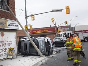 Emergency crews work at the scene of a two-vehicle collision at the intersection of Lincoln Rd. and Tecumseh Rd. East, Thursday, April 25, 2019.  One car was t-boned and ended up on its side, up against a building.  No major injuries were reported.