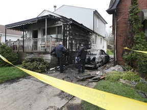 Windsor fire investigators examine the aftermath of an incident in the 2200 block of Parkwood Avenue on April 29, 2019. The fire started in a car between the two houses.