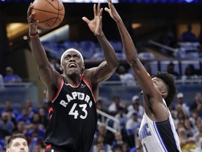 Raptors' Pascal Siakam (centre) shoots against Magic's Nikola Vucevic (left) and Jonathan Isaac (right) during first half NBA playoff action in Orlando, Fla., Friday, April 19, 2019.