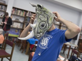 Student Kai Dutton, 17, is shown trying on a rhino mask the cast of Rhinoceros were making  April 8, 2019, with the help of Deb Erb, a Waterloo-based freelance theatre artist, in the Walkerville Collegiate library. Twenty masks for the play were made from camping mats, mesh baseball hats and tissue paper mache.