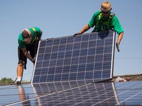 SolarCity Corp. employees install solar panels on the roof of a home in Kendall Park, New Jersey.