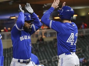 Blue Jays' Teoscar Hernandez, left, celebrates his go-ahead three-run home run off Twins' pitcher Adalberto Mejia with Randal Grichuk in the eighth inning of an MLB game Monday, April 15, 2019, in Minneapolis.