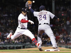 Boston Red Sox's Mookie Betts, left, legs out a single as Detroit Tigers first baseman Miguel Cabrera (24) catches the throw during the seventh inning of a baseball game at Fenway Park, Wednesday, April 24, 2019, in Boston.