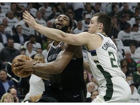 Detroit Pistons' Andre Drummond, left, drives to the basket against Milwaukee Bucks' Pat Connaughton during the first half of Game 1 of an NBA basketball first-round playoff series Sunday, April 14, 2019, in Milwaukee.