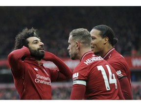 Liverpool's Mohamed Salah, left, celebrates with teammates after scoring his side's second goal during the English Premier League soccer match between Liverpool and Chelsea at Anfield stadium in Liverpool, England, Sunday, April 14, 2019.