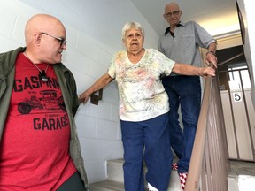 Due to a broken elevator, Dave Laframboise, left, stays in front of his parents, Doreen and Frank Laframboise as they go down their apartment building stairs May 2, 2019.