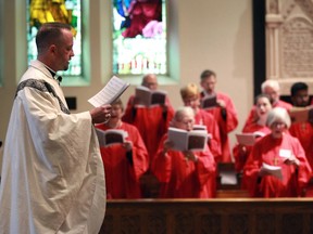 Rev. Robert Clifford sings along with the choir during Easter Sunday mass, The Resurrection of Our Lord, at All Saints' Anglican Church at City Hall Square, April 21, 2019.