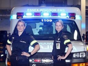 Essex-Windsor EMS paramedics Heather Ryall, left, and Kristen Key stand in front of one of  seven ambulances already fitted with new blue lights in combination with red, to provide better visibility.