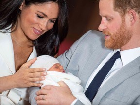 Britain's Prince Harry, Duke of Sussex, and his wife Meghan, Duchess of Sussex, pose for a photo with their newborn baby son, Archie Harrison Mountbatten-Windsor, in St George's Hall at Windsor Castle in Windsor, west of London on May 8, 2019.