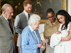 In this image made available by SussexRoyal on May 8, 2019, Britain's Prince Harry and Meghan, Duchess of Sussex, joined by her mother Doria Ragland, show their new son to Queen Elizabeth II and Prince Philip at Windsor Castle, Windsor, England. Prince Harry and Meghan have named their son Archie Harrison Mountbatten-Windsor.