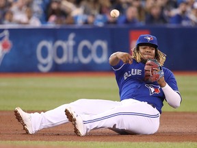 Vladimir Guerrero Jr. of the Toronto Blue Jays throws from the seat of his pants to get the baserunner at first base against the Boston Red Sox at Rogers Centre on May 23, 2019 in Toronto. (Tom Szczerbowski/Getty Images)