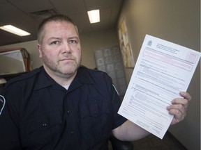 Todd Hamilton, a by-law enforcement officer, holds up a Dirty Yard order, Tuesday, May 14, 2019.   The by-law went into effect last week.