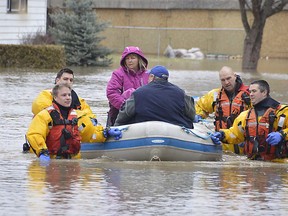 Members of the Chatham-Kent fire service dive team help residents whose homes were flooded in Chatham. Photograph taken on Feb. 28, 2019. (Louis Pin/Postmedia News)