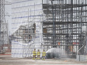 City fire crews extinguish a fire in west Windsor on May 9, 2019. A large piece of tarp flew off a construction site, made contact with nearby high-voltage power lines, triggering widespread city blackouts and causing a field blaze.