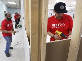 Employees from Keller Williams Realty in Windsor spent Thursday, May 9, 2019, transforming the Kids First Food Bank at Windsor Family Homes & Community Partnerships. The company's annual Red Day event gives employees an opportunity to take a day away from the office and donate time to their community. Roger James, left, and Isaac Verge are shown drywalling a section of the new food bank.