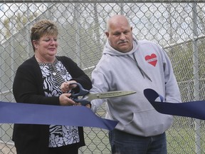 Kim Gauthier is overcome with emotion as she and husband Scott Gauthier cut the ceremonial ribbon to officially open Windsor Central Little League's new batting cage in Optimist Memorial Park. The batting cage is named after the Gauthers' son Chance, a sports-loving 16-year-old who was killed last year in a downtown shooting.