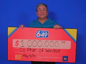 Co Phan of Windsor stands with his prize cheque for winning the Guaranteed $1 Million prize at Lotto 6/49, May 4, 2019.