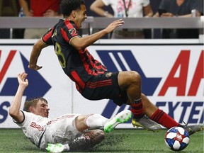 Atlanta United forward Dion Pereira (28) is tripped by a Toronto FC defender during the second half of an MLS soccer match in Atlanta on May 8, 2019.