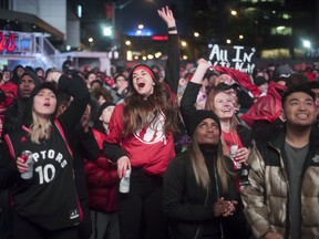 In this Sunday, May 12, 2019, file photo, basketball fans cheer for the Toronto Raptors before claiming victory over the Philadelphia 76ers outside Maple Leaf Square during the second half of an NBA Eastern Conference semifinal basketball game in Toronto. For Raptors games, Maple Leaf Square, aka Jurassic Park, boasts a college vibe of rowdy fans crammed into an area that covers two city blocks.
