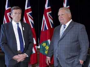 Toronto Mayor John Tory, left, and Ontario Premier Doug Ford stand for a photo opp in Ford's Queen's Park office in Toronto on December 6, 2018. Ontario's municipalities say they may be forced to raise taxes or cut services due to provincial government cuts that will likely equal well over half a billion dollars in lost annual funding and foregone revenue.