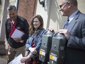 Jordyn Deschaime, centre, is joined by Bill Kralovensky, left, supervisor of Parking Compliance and Enforcement, and Mayor Drew Dilkens, after receiving a 100,000 free uses on the Passport Parking app on May 21, 2019.