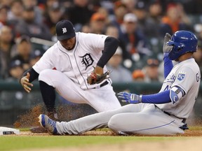 Kansas City Royals' Kelvin Gutierrez beats the tag of Detroit Tigers third baseman Jeimer Candelario for an RBI triple during the fourth inning of a baseball game Friday, May 3, 2019, in Detroit.