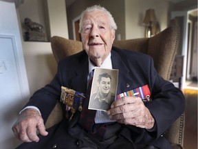 Charles Davis, 96, of Windsor, is one of 14 veterans that Canada is sending to the 75th anniversary of D-Day and the Battle of Normandy. He is shown at his daughter's home on Wednesday, May 15, 2019 holding a photo of himself when he was 22 and actively involved in World War II.