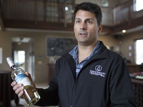 Steve Mitchell, president of Sprucewood Shores Estate Winery, holds a bottle of 2018 Pinot Grigio, while discussing the 35% import tax, Wednesday, May 8, 2019.  The bottle costs $14.95 at the LCBO but could be reduced to approximately $11 if the tax was removed.