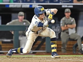 Jack Blomgren of the Michigan Wolverines lays down a bunt for a single in the ninth inning against the Vanderbilt Commodores during game one of the College World Series Championship Series on June 24, 2019 at TD Ameritrade Park Omaha in Omaha, Nebraska.