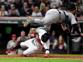Jason Kipnis #22 of the Cleveland Indians scores as catcher Bobby Wilson #37 of the Detroit Tigers is knocked over after making the catch during the eighth inning at Progressive Field on June 21, 2019 in Cleveland, Ohio.