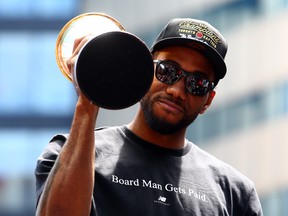 Kawhi Leonard holds his MVP trophy during the Raptors' victory parade in Toronto on Monday. (Vaughn Ridley/Getty Images)