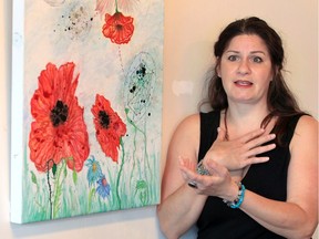 Artist and curator Christine Paris is shown June 12, 2019, with her acrylic and ink on canvas titled 'Creation' at Core Gallery.