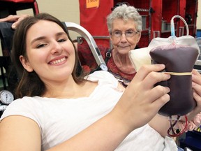 Cardinal Carter Catholic Secondary School student Mackenzie Cassidy, 17,  holds her blood donation during Gift of Life Boys vs. Girls blood drive competition at Leamington's Kinsmen Recreation Centre Friday.  In all, 70 units of blood were donated during the event which is also known as the Bates Blood Drive, named after the longtime teacher Mark Bates.  In photo, Bates' mother Fay Bates, right, converses with Cassidy.