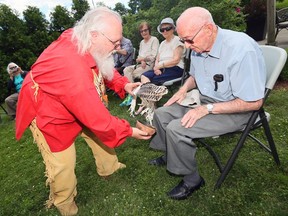 Bill Mattice, left, dressed in moose moccasins, buckskin pants and a chest plate of various bones, performs a Native smudging ceremony at Amica Riverside senior living Friday. Resident Murray Sutton, right, had issues with sore back and knees which were targeted by Mattice.
