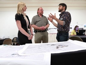 Stephanie Campeau, left, Windsor-Detroit Bridge Authority speaks with Mark Bartlett, Unifor's community environmental representative and Jonathan Choquette, right, a conservation biologist during Windsor-Detroit Bridge Authority and Bridging North America public meeting to discuss the Gordie Howe International Bridge construction Tuesday at Mackenzie Hall.