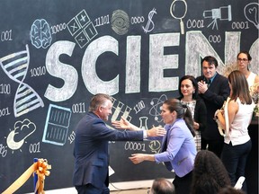 Hon. Kirsty Duncan, Minister of Science and Sport and Douglas Kneale, left, University of Windsor interim president, embrace as hundreds of staff, students and guests applaud the grand opening of the U of W's Essex Centre of Research (Essex CORe).  Minister Duncan was once faculty at the University of Windsor for 7.5 years before entering politics.