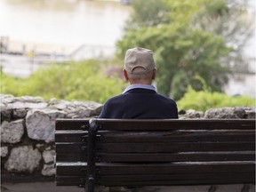 A senior sits on a bench.