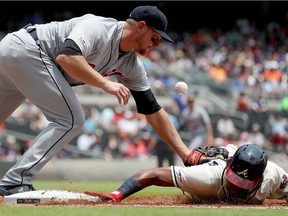 Detroit Tigers first baseman John Hicks misses the ball on a pick off attempt of Atlanta Braves left fielder Ronald Acuna Jr. at first base in the first inning at SunTrust Park.