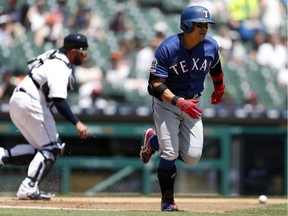 Texas Rangers designated hitter Shin-Soo Choo (17) starts running to first base as Detroit Tigers catcher Bobby Wilson (37) runs to the ball during the third inning at Comerica Park. Mandatory Credit: Raj Mehta-USA TODAY Sports