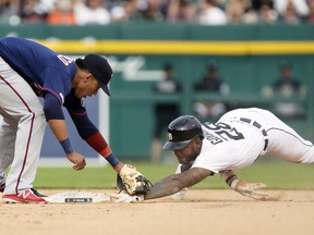 Niko Goodrum of the Detroit Tigers keeps his fingers on second base after making the steal as shortstop Jorge Polanco of the Minnesota Twins maintains the tag during the sixth inning at Comerica Park on June 8, 2019 in Detroit, Michigan.