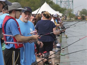 James Benvenuto and his father Mario Benvenuto participate in the ICHA Handicapable Fishing Derby on Saturday, June 1, 2019, at the Assumption Park in Windsor.
