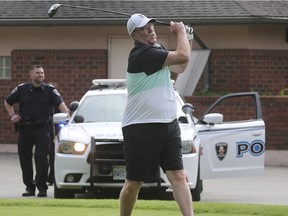 The inaugural Can-Am Golf Series event in support of the 2022 Can-Am Police-Fire Games was held on Monday, June 17, 2019, at the Roseland Golf Club. Participant Pat Reekers tees off under the watchful eye of a Windsor Police officer during the event.