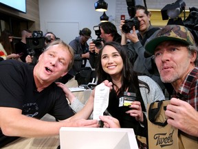 Canopy Growth Corp. CEO Bruce Linton, left, sells the first legal recreational marijuana to Nikki Rose and Ian Power in St. Johns, Newfoundland on Oct. 16, 2018.